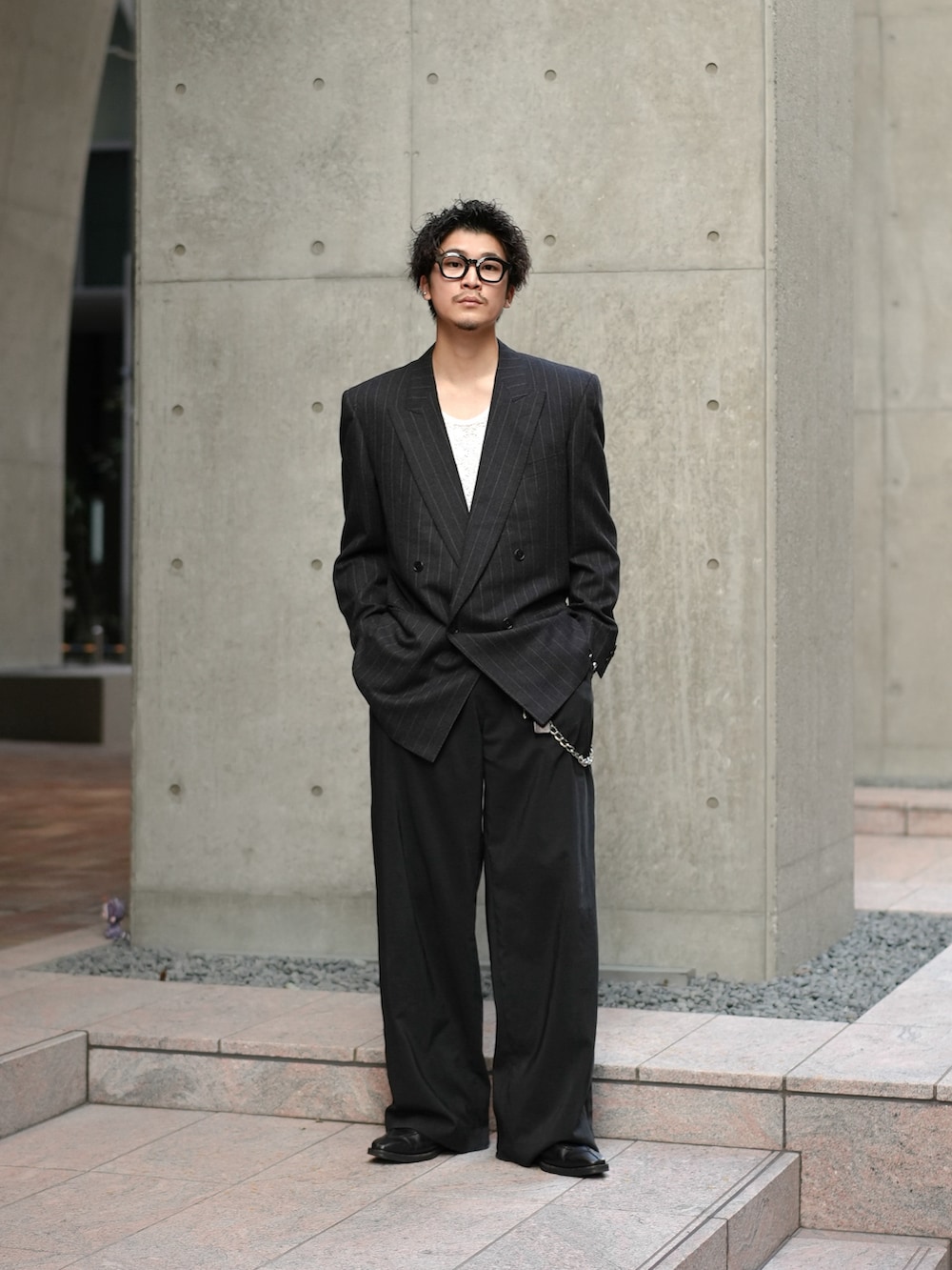 ブラック系のテーラードジャケット、ホワイト系のシャツ/ブラウス、ブラック系のスラックスを着用したメンズの秋コーディネートの2枚目の写真