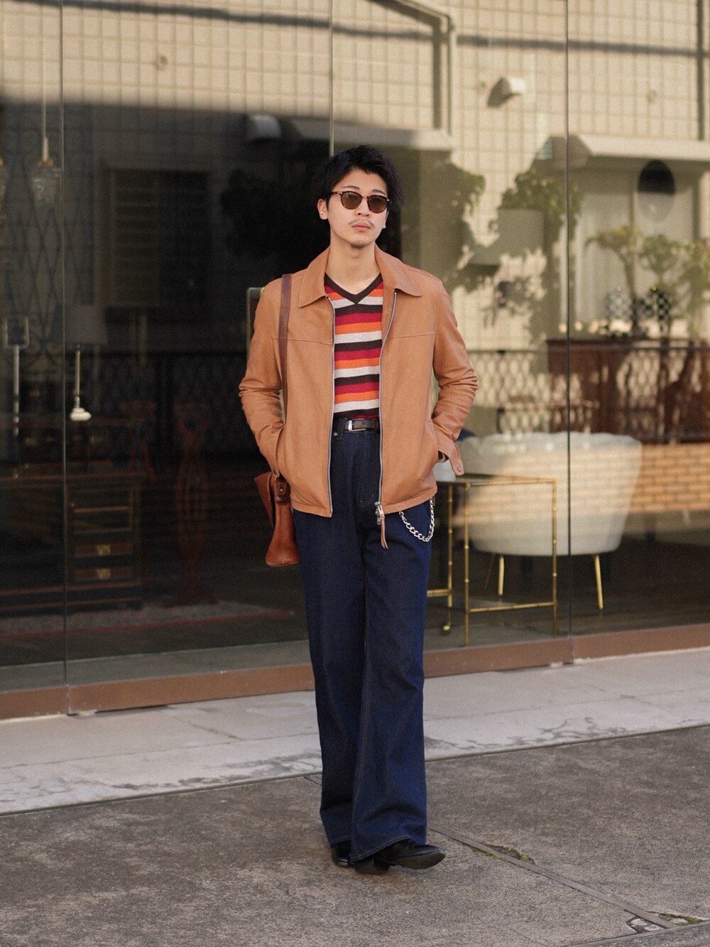 ブルー系のデニムパンツ、ベージュ系のその他アウター、レッド系のニット/セーターを着用したメンズの春コーディネートの5枚目の写真