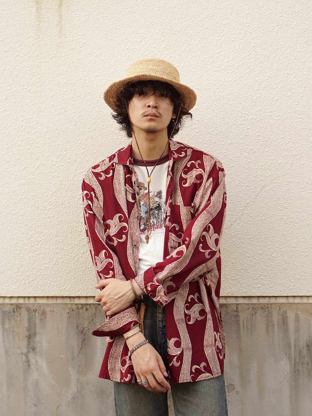 ブルー系のデニムパンツ、ブラック系のブーツ、レッド系のシャツ/ブラウスを着用したメンズの夏コーディネートの3枚目の写真