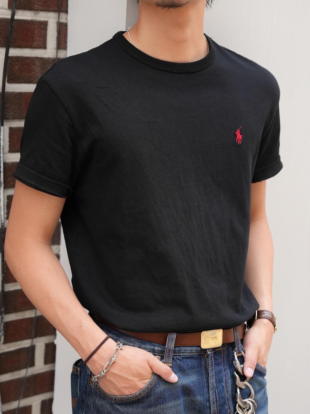ブラック系のTシャツ/カットソー、ブルー系のデニムパンツ、ブラック系のブーツを着用したメンズの夏コーディネートの3枚目の写真