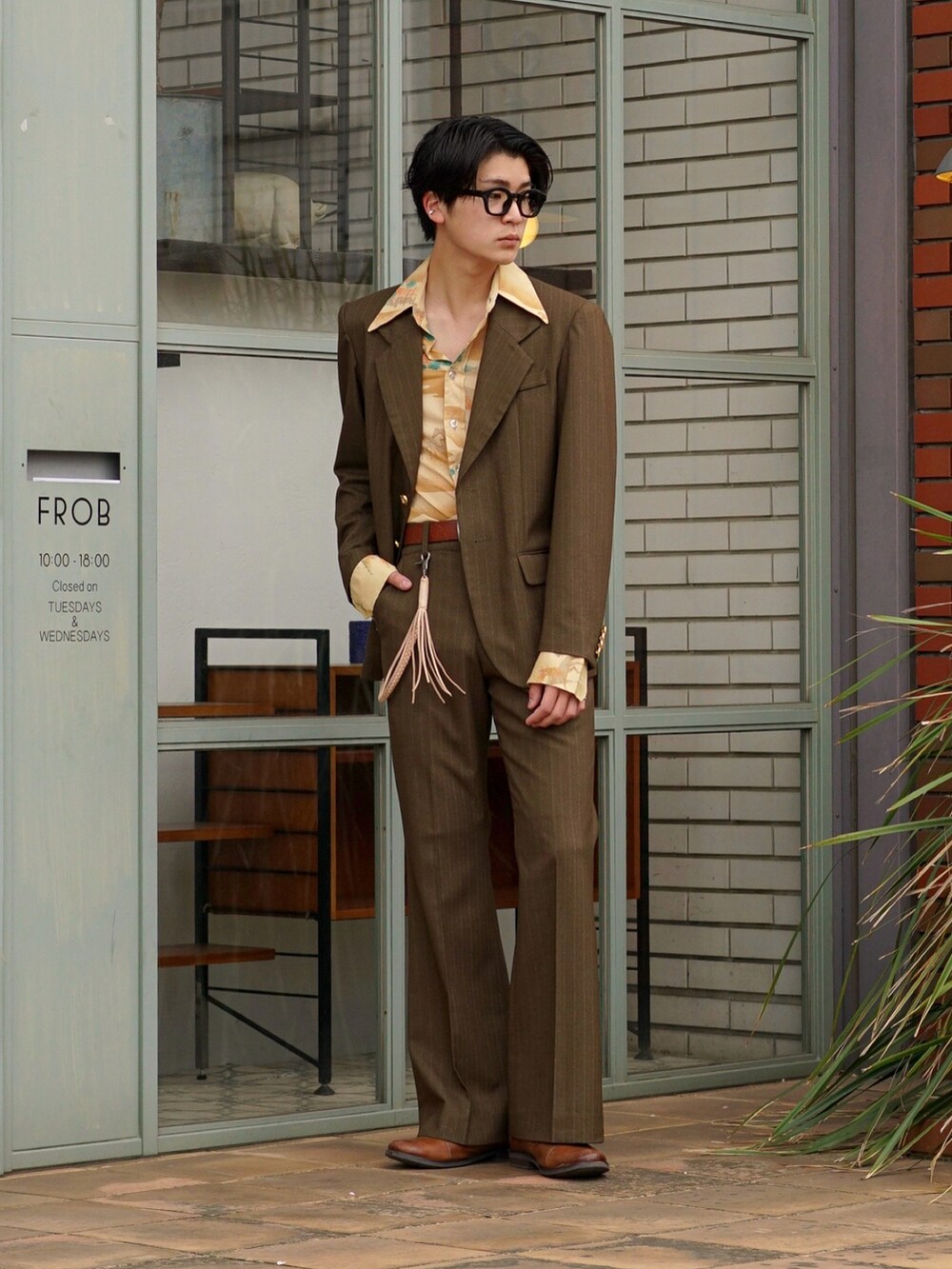 グリーン系のスラックス、グリーン系のテーラードジャケット、イエロー系のシャツ/ブラウスを着用したメンズの春コーディネートの2枚目の写真