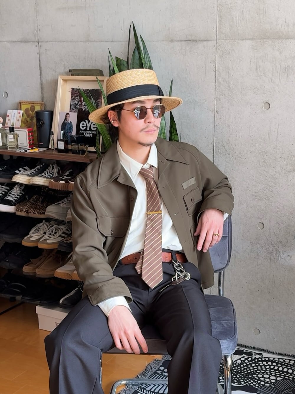 グリーン系のミリタリージャケット、ブラック系のスラックス、ブラウン系のブーツを着用したメンズの春コーディネートの2枚目の写真