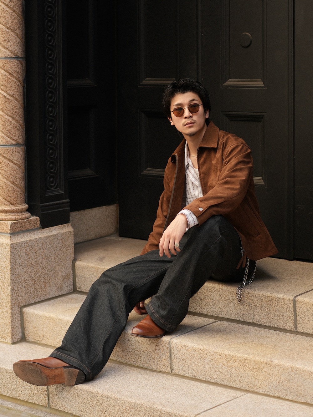 ブラック系のデニムパンツ、ブラウン系のブーツ、ホワイト系のシャツ/ブラウスを着用したメンズの秋コーディネートの3枚目の写真