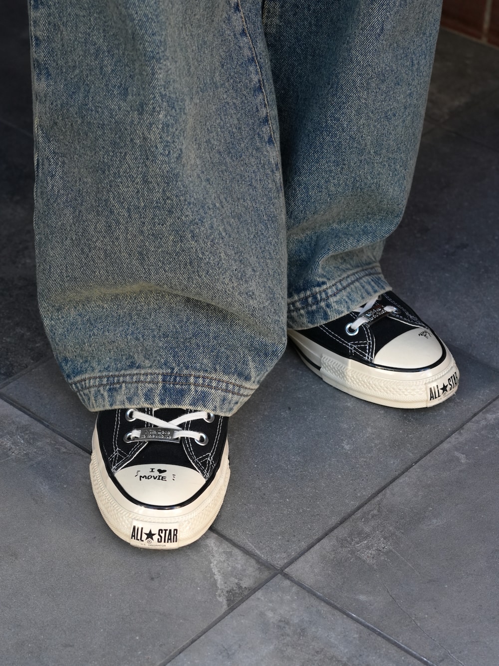 ブラック系のテーラードジャケット、ホワイト系のタンクトップ、ブルー系のデニムパンツを着用したメンズの冬コーディネートの4枚目の写真