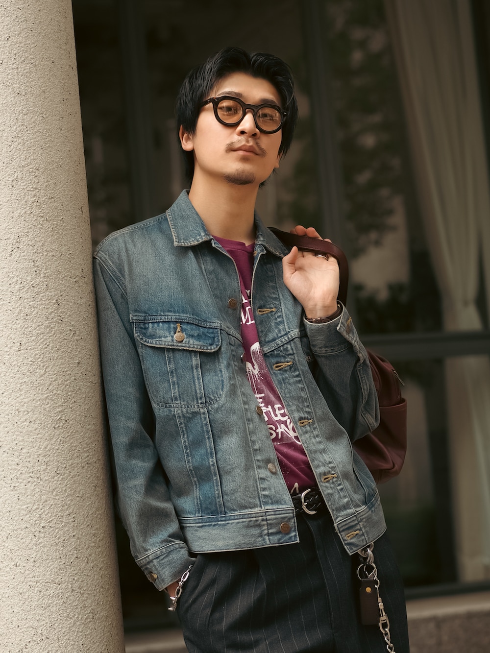ブルー系のデニムジャケット、レッド系のTシャツ/カットソー、ブラック系のスラックスを着用したメンズの春コーディネートの2枚目の写真