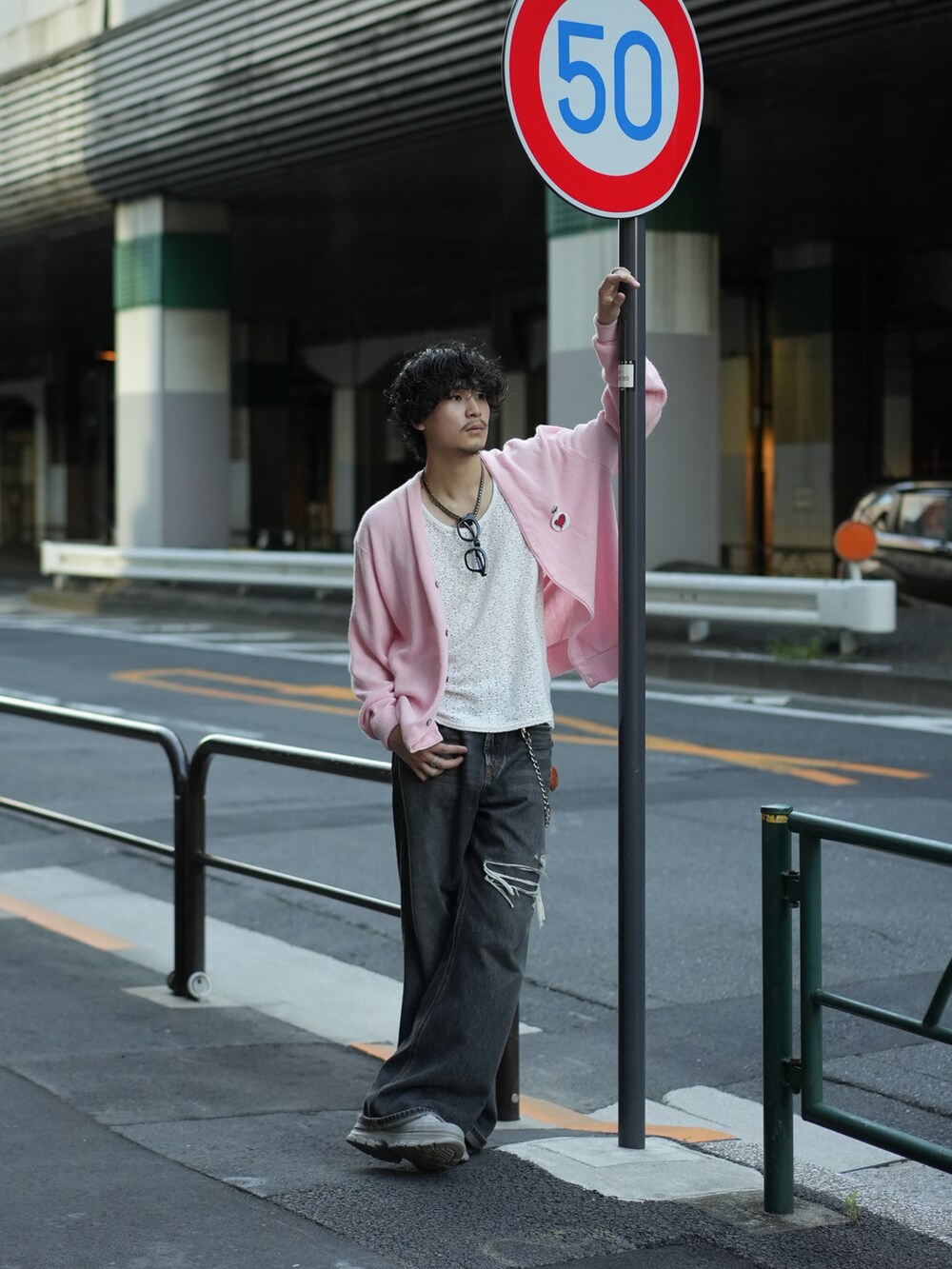 ブラック系のデニムパンツ、グレー系のスニーカー、ピンク系のカーディガン/ボレロを着用したメンズの秋コーディネートの2枚目の写真