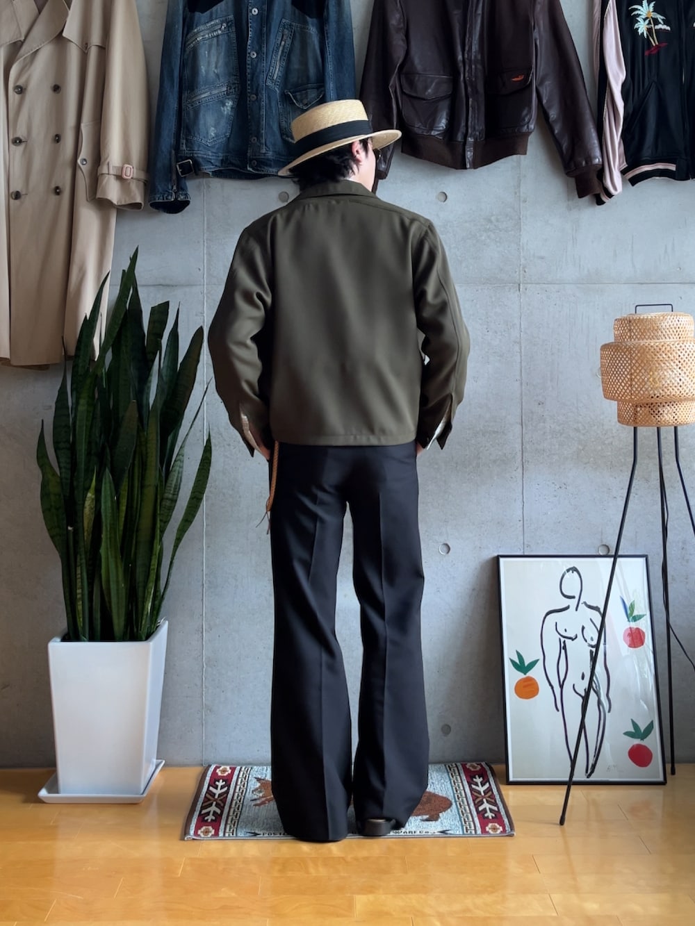 ブラック系のスラックス、グリーン系のミリタリージャケット、ブラック系のスリッポンを着用したメンズの秋コーディネートの2枚目の写真