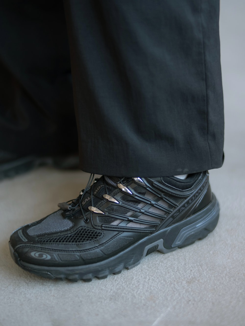 ホワイト系のタンクトップ、ブラック系のショルダーバッグ、ブラック系のスニーカーを着用したメンズの夏コーディネートの3枚目の写真