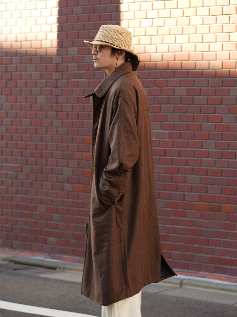 ブラック系のハンドバッグ、ホワイト系のその他パンツ、ブラック系のドレスシューズを着用したメンズの秋コーディネートの4枚目の写真