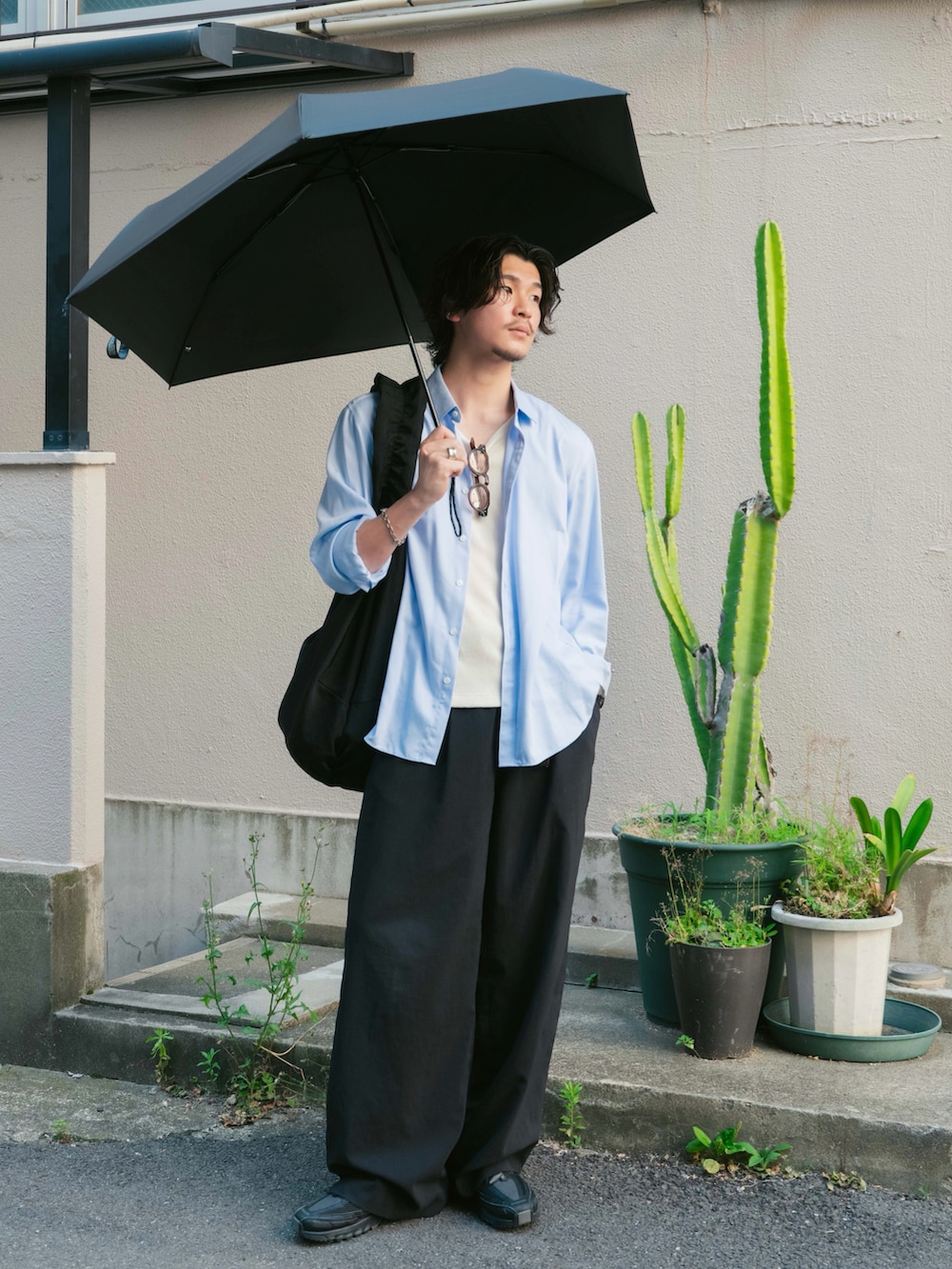 ホワイト系のタンクトップ、ブラック系のショルダーバッグ、ブラック系のスニーカーを着用したメンズの夏コーディネートの5枚目の写真