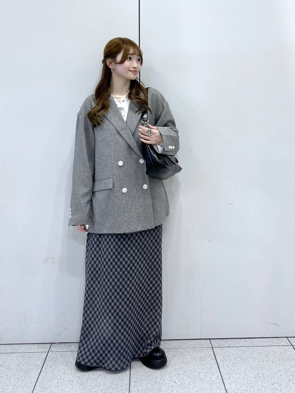 ホワイト系のニット/セーター、グレー系のテーラードジャケット、ブラック系のショルダーバッグを着用したレディースの冬コーディネートの5枚目の写真