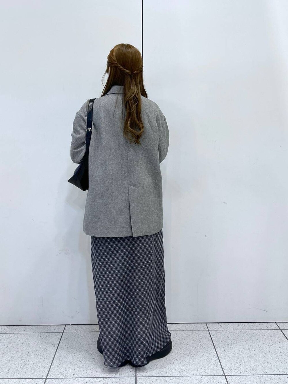 ホワイト系のニット/セーター、グレー系のテーラードジャケット、ブラック系のショルダーバッグを着用したレディースの冬コーディネートの3枚目の写真