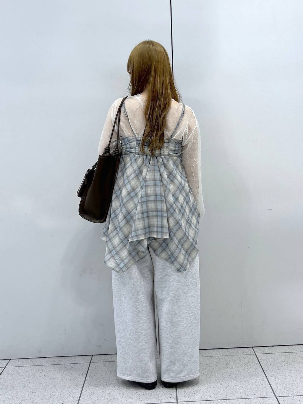 グレー系のスウェットパンツ、ブラック系のパンプス、ブラウン系のトートバッグを着用したレディースの春コーディネートの3枚目の写真