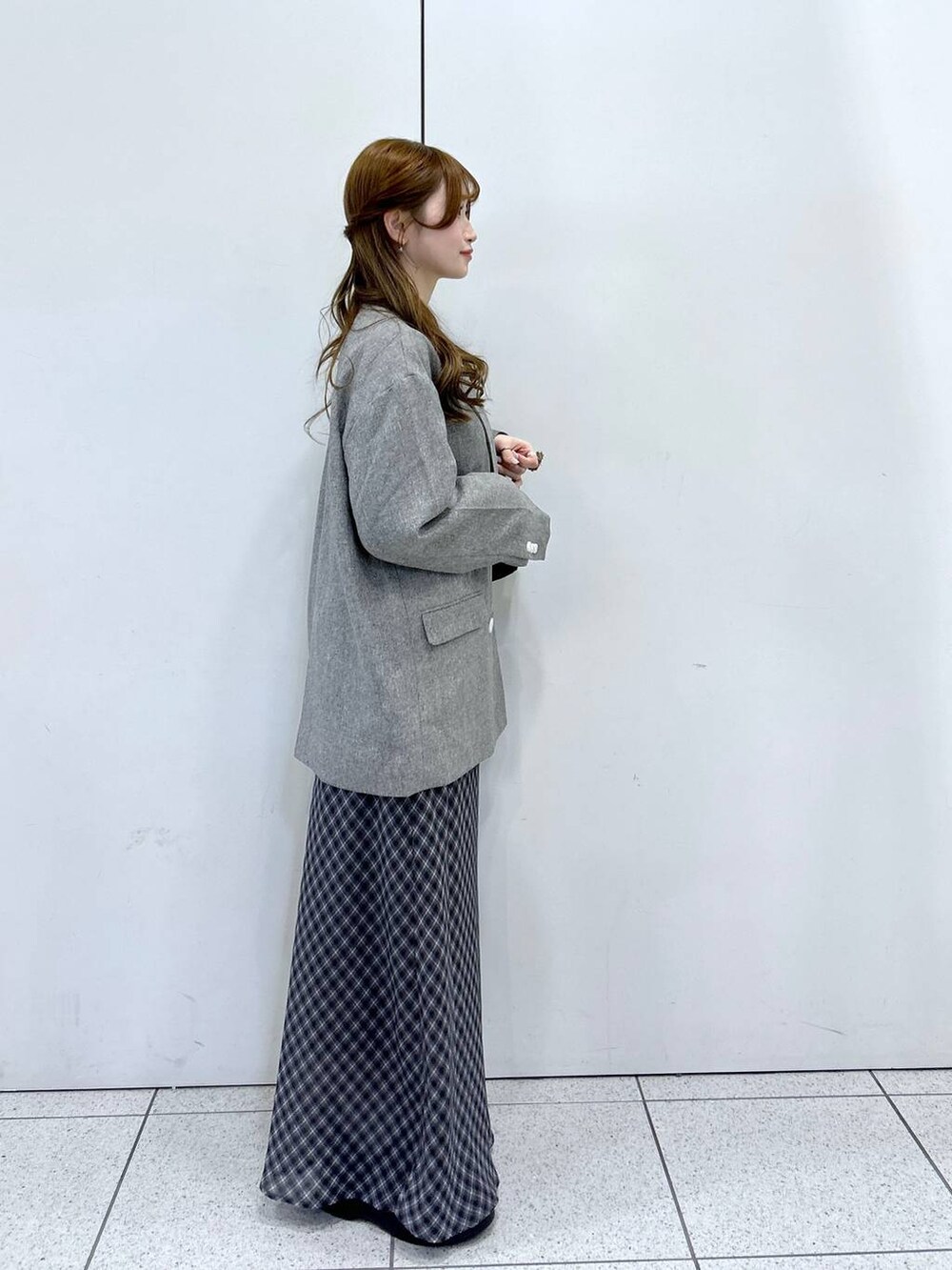 ホワイト系のニット/セーター、グレー系のテーラードジャケット、ブラック系のショルダーバッグを着用したレディースの冬コーディネートの2枚目の写真