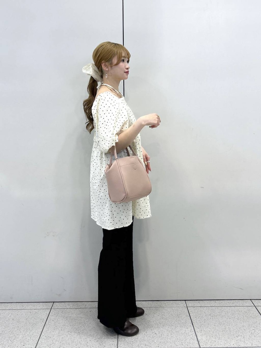 ピンク系のショルダーバッグ、ブラウン系のサンダル、ブラック系のその他パンツを着用したレディースの春コーディネートの2枚目の写真