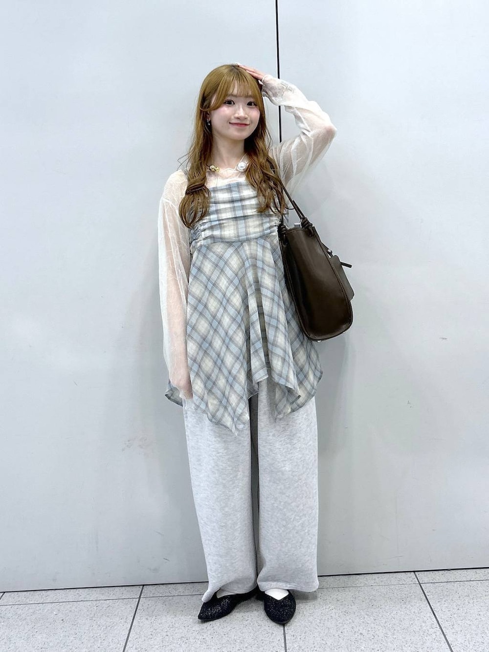 グレー系のスウェットパンツ、ブラック系のパンプス、ブラウン系のトートバッグを着用したレディースの春コーディネートの4枚目の写真