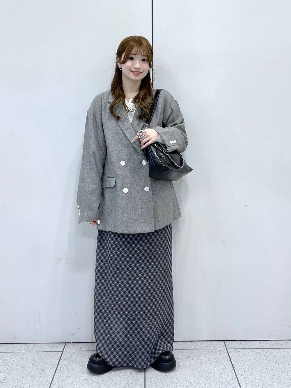 ホワイト系のニット/セーター、グレー系のテーラードジャケット、ブラック系のショルダーバッグを着用したレディースの冬コーディネートの4枚目の写真