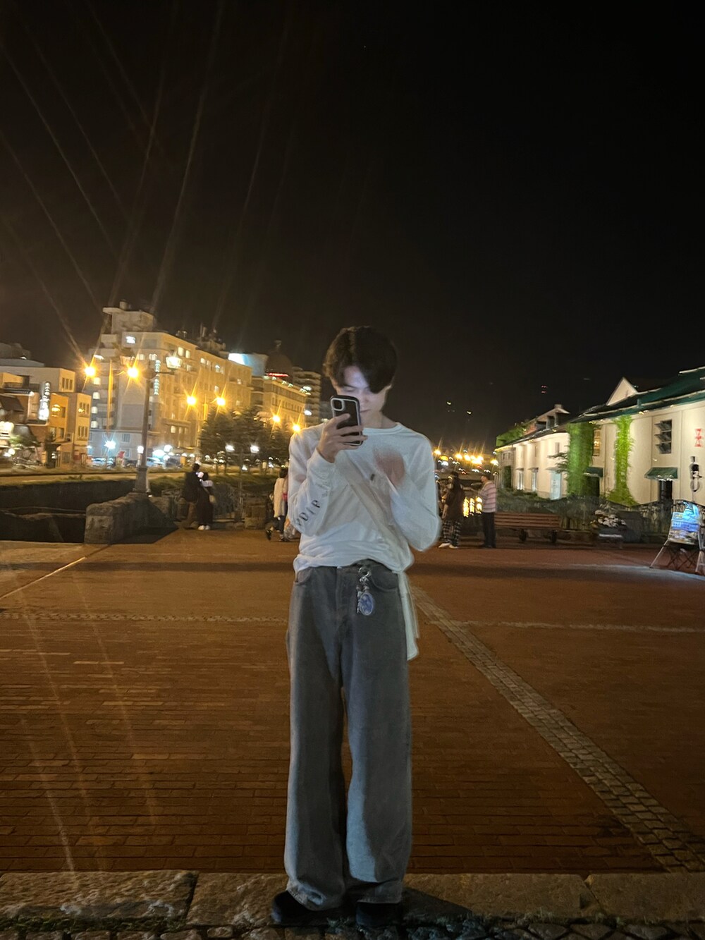 グレー系のデニムパンツ、ホワイト系のTシャツ/カットソー、ホワイト系のメッセンジャーバッグを着用したメンズの夏コーディネートの2枚目の写真