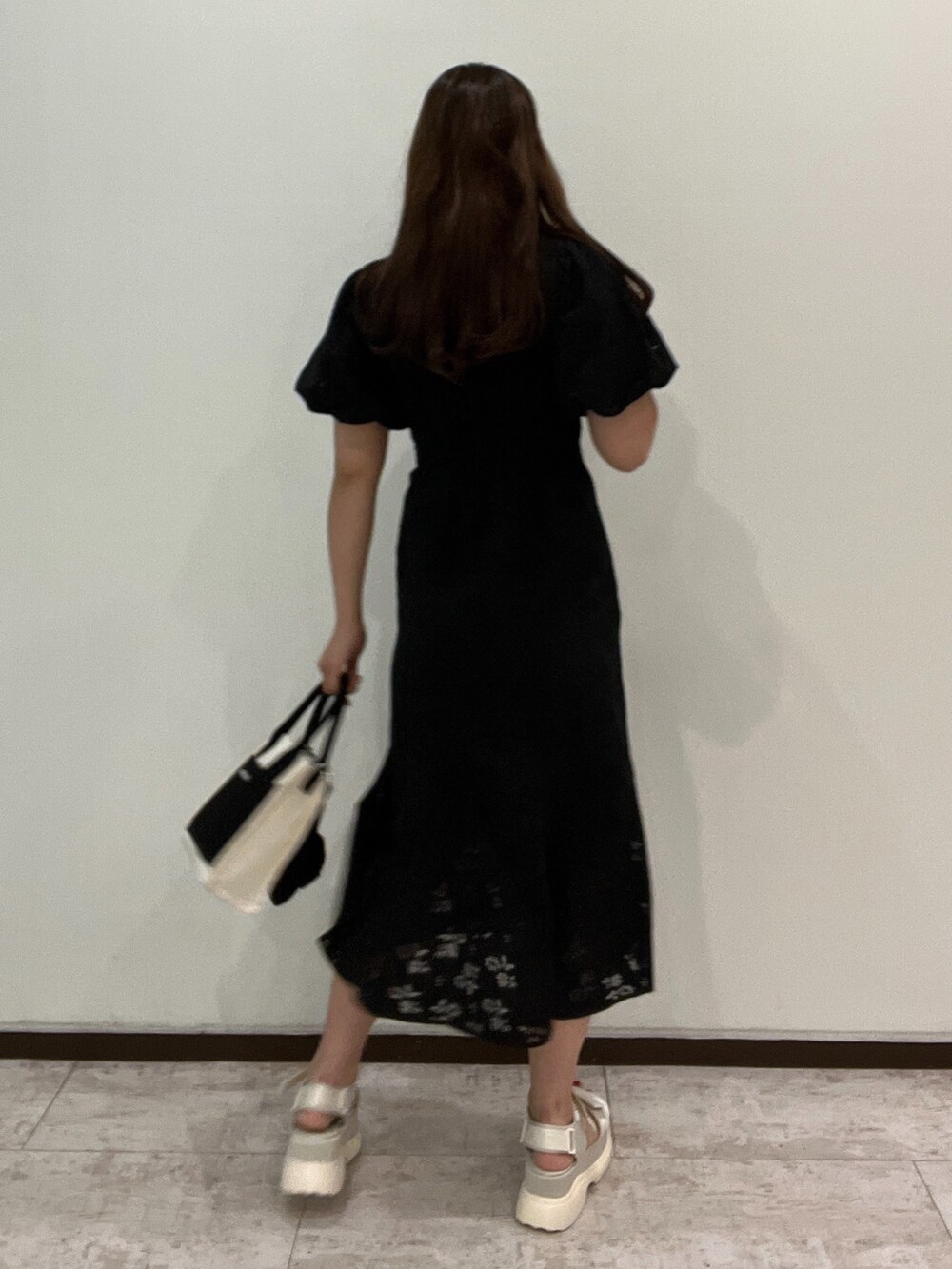 ブラック系のワンピース、ブラック系のショルダーバッグ、ホワイト系のサンダルを着用したレディースの春コーディネートの3枚目の写真