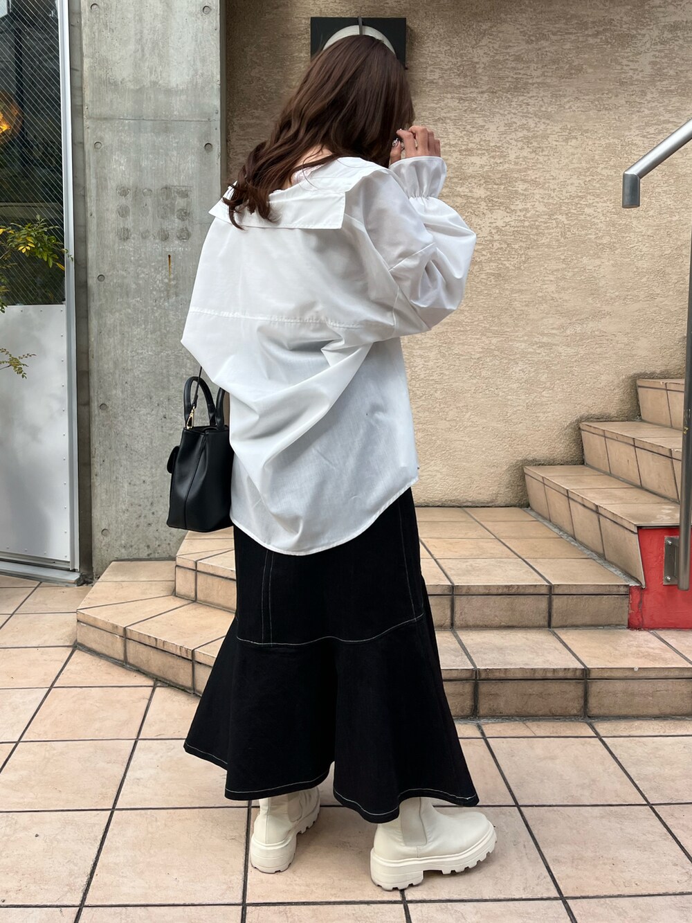 ホワイト系のシャツ/ブラウス、ブラック系のスカート、ブラック系のショルダーバッグを着用したレディースの春コーディネートの3枚目の写真