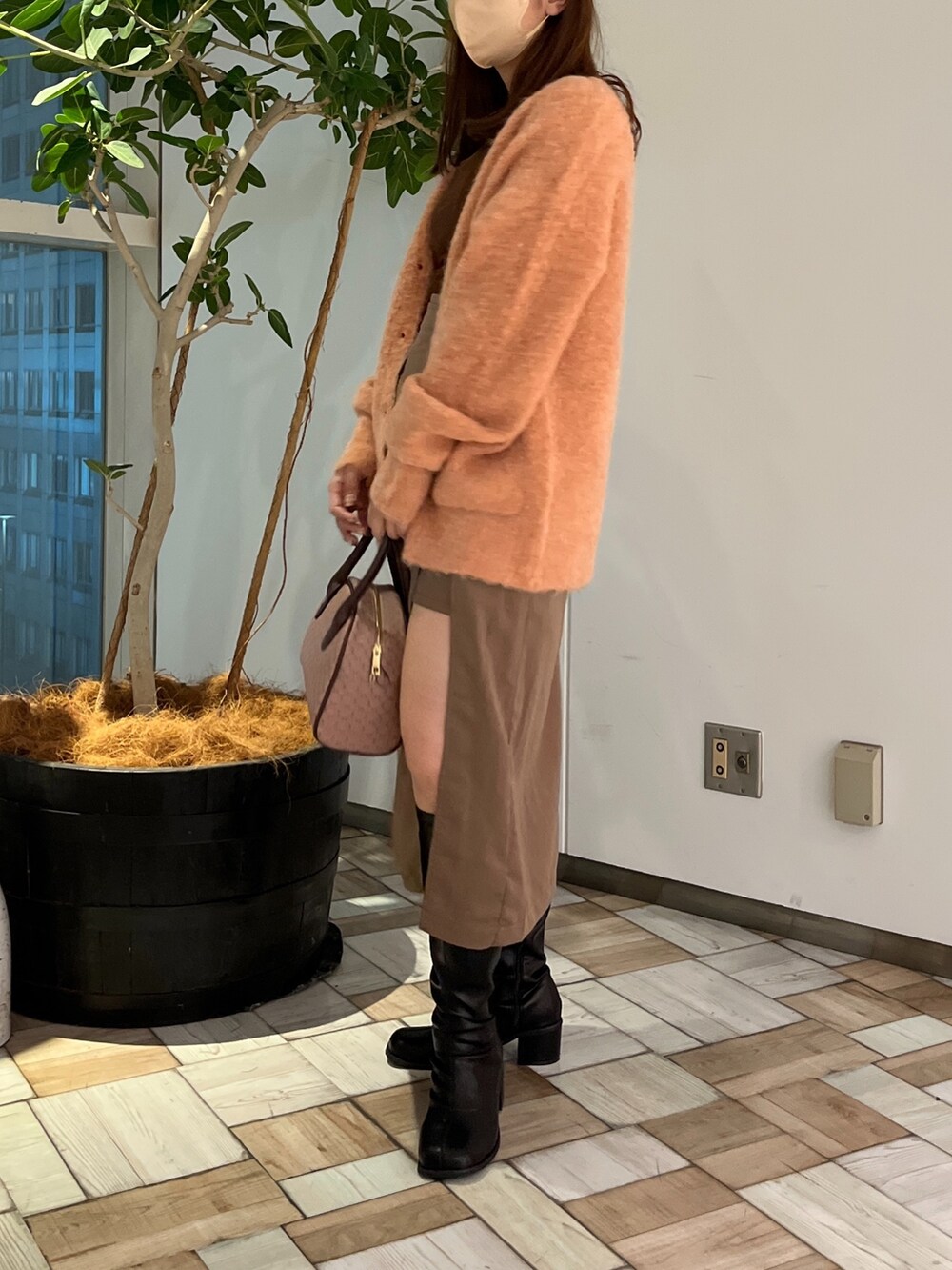ブラウン系のスカート、ブラック系のその他シューズ、ブラウン系のボストンバッグを着用したレディースの秋コーディネートの3枚目の写真