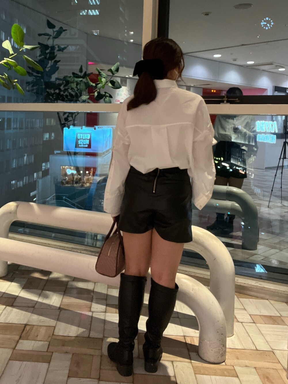 ブラック系のスカート、ブラウン系のボストンバッグ、ホワイト系のシャツ/ブラウスを着用したレディースの秋コーディネートの2枚目の写真