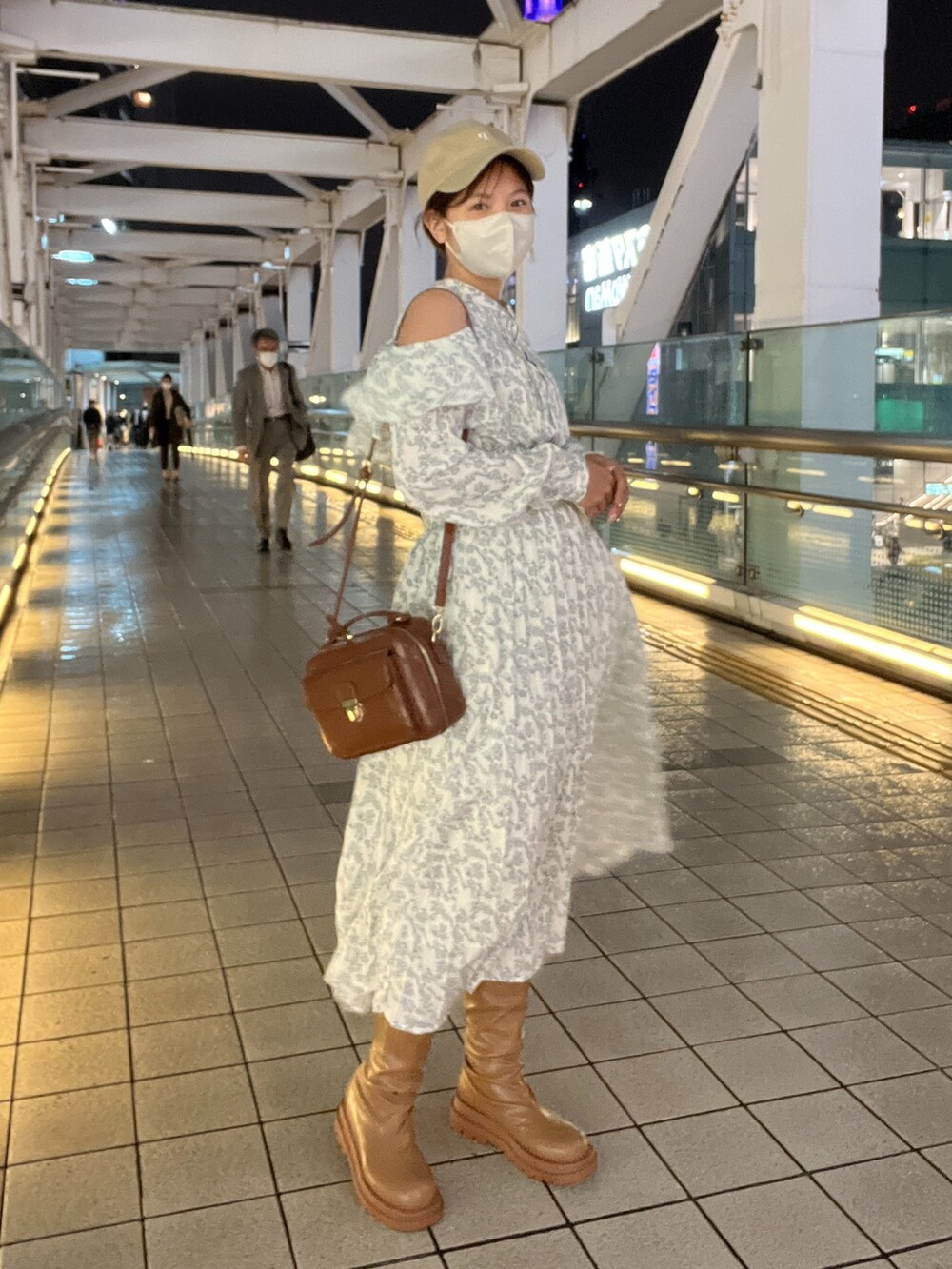 イエロー系のショルダーバッグ、ホワイト系のワンピース、イエロー系のブーツを着用したレディースの秋コーディネートの3枚目の写真