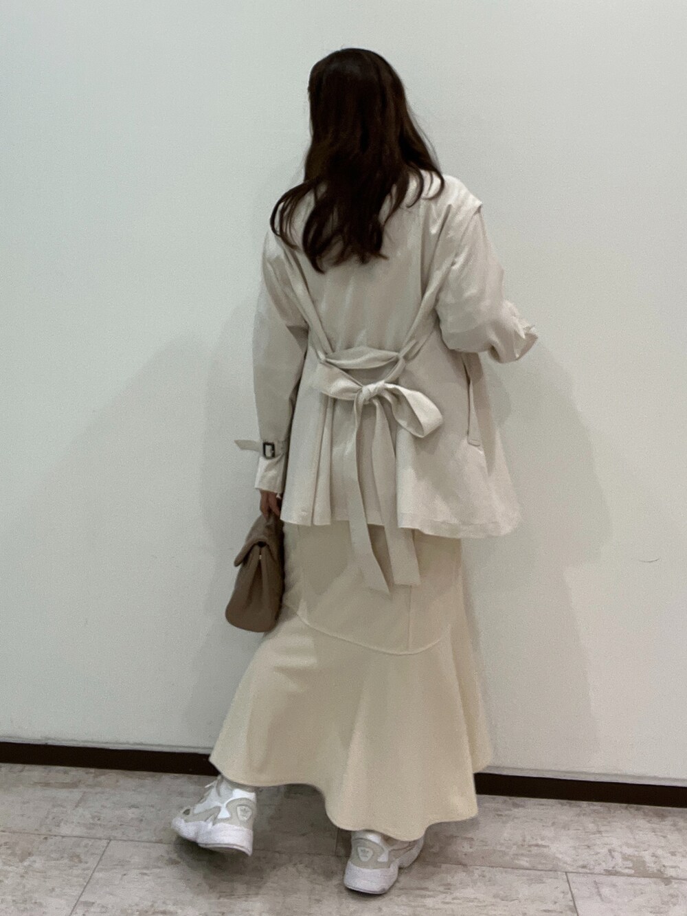 ホワイト系のシャツ/ブラウス、ホワイト系のトレンチコート、ベージュ系のショルダーバッグを着用したレディースの春コーディネートの2枚目の写真