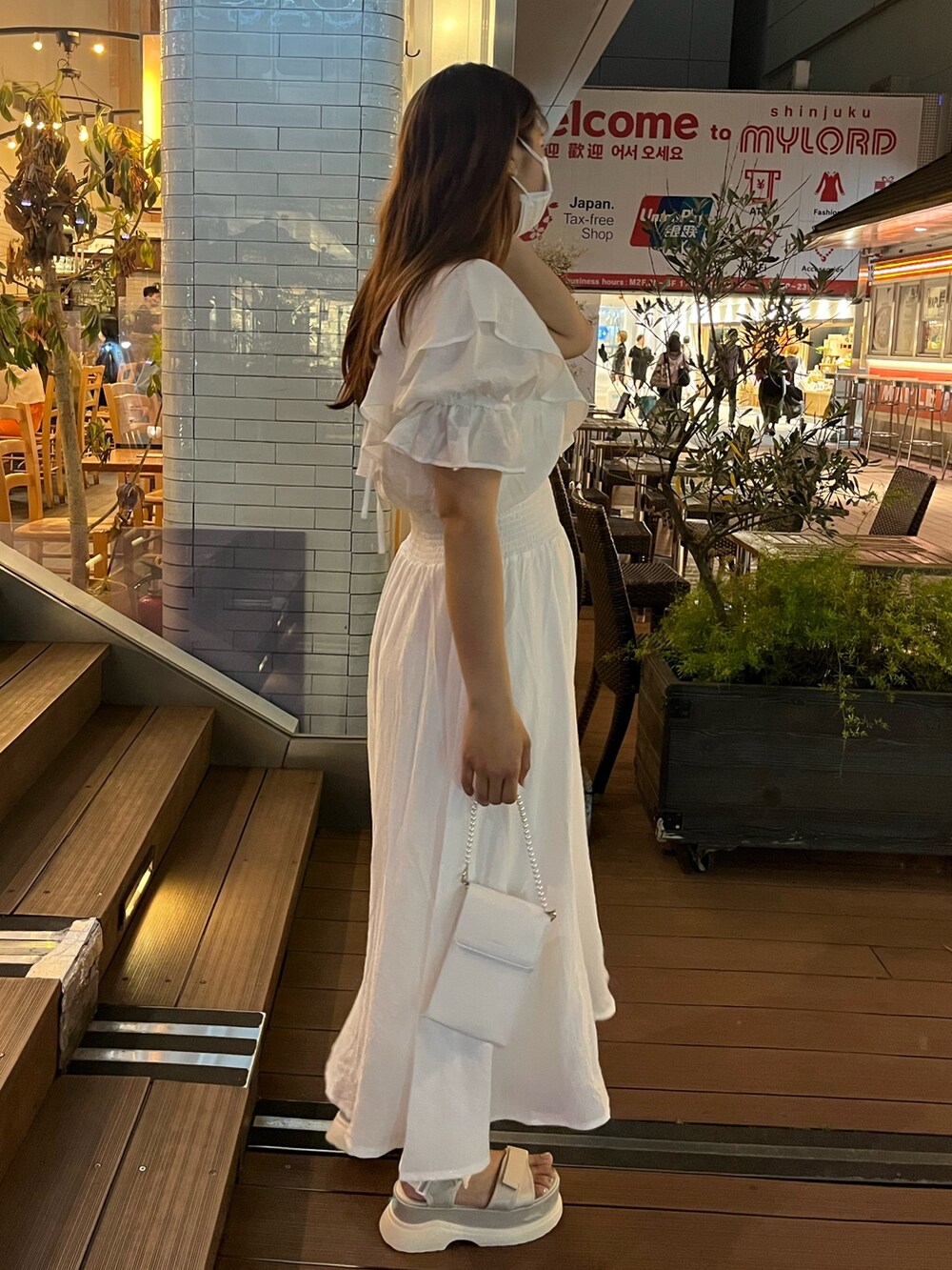 ホワイト系のワンピース、ホワイト系のショルダーバッグ、ホワイト系のサンダルを着用したレディースの夏コーディネートの2枚目の写真