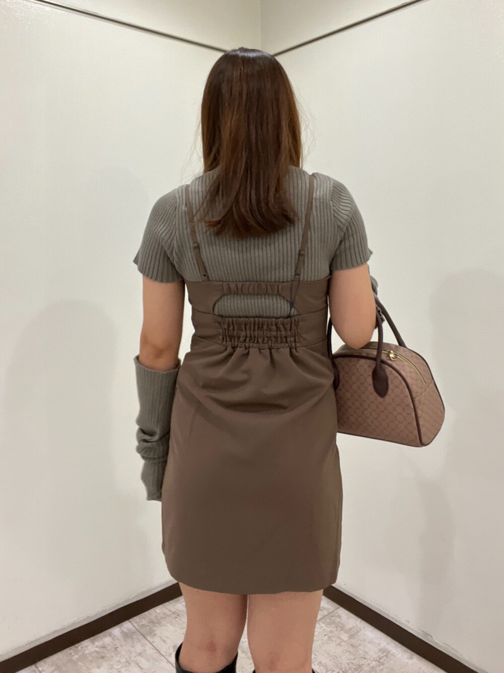 グリーン系のニット/セーター、ブラウン系のワンピース、ブラウン系のボストンバッグを着用したレディースの秋コーディネートの3枚目の写真