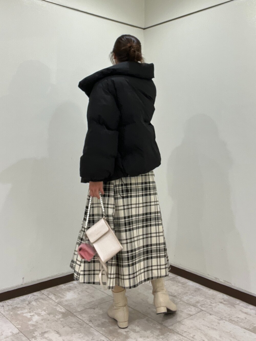 ブラック系のダウンジャケット/コート、ホワイト系のニット/セーター、その他のスカートを着用したレディースの冬コーディネートの2枚目の写真