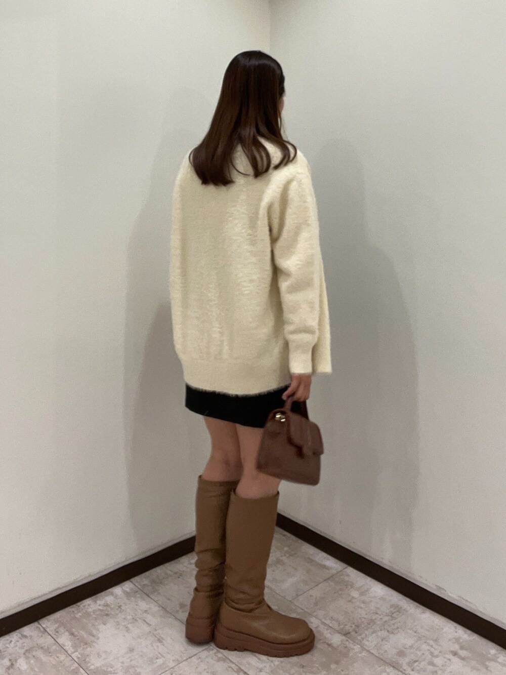 ホワイト系のニット/セーター、ブラック系のワンピース、ホワイト系のカーディガン/ボレロを着用したレディースの秋コーディネートの4枚目の写真