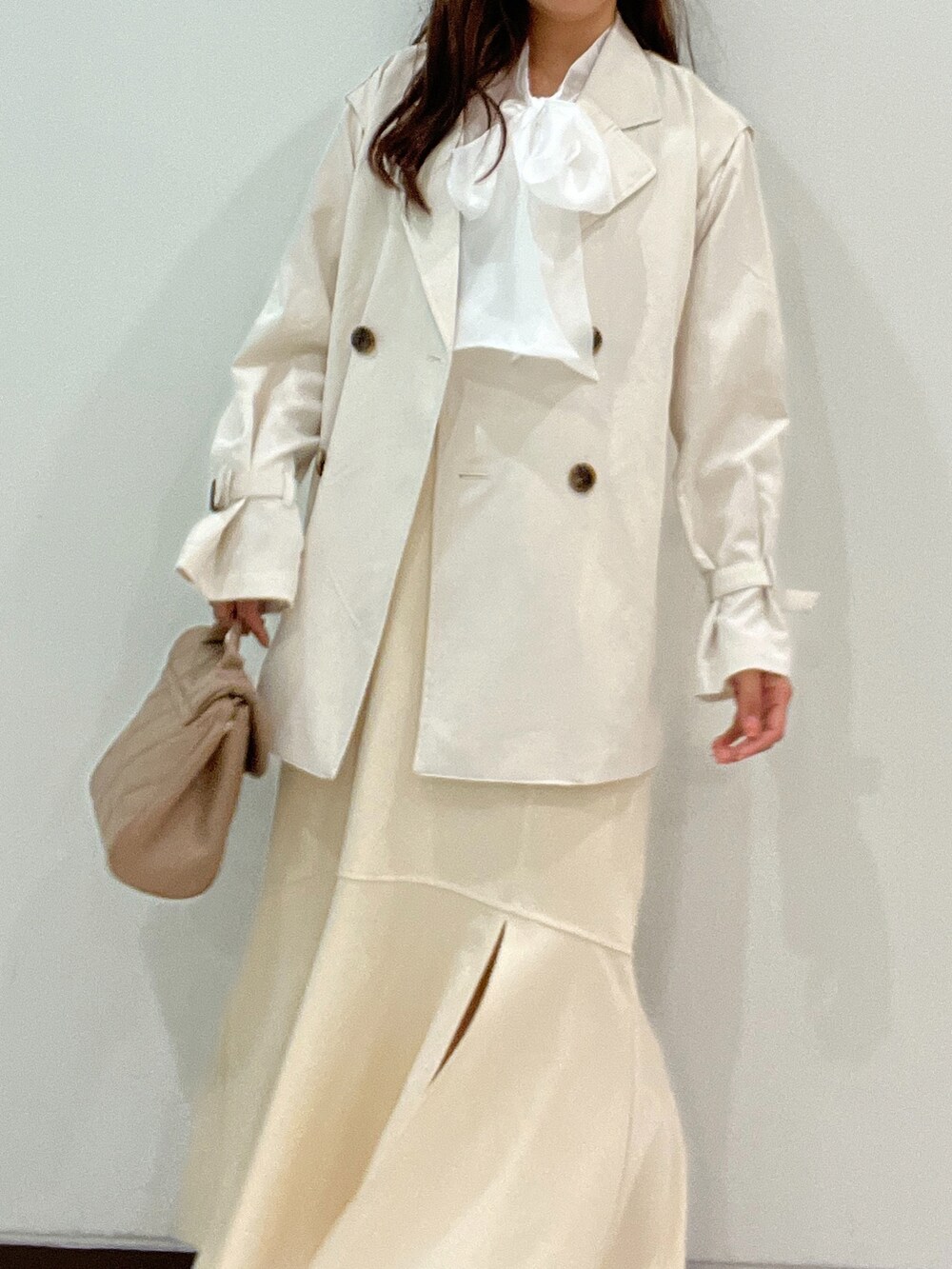 ホワイト系のシャツ/ブラウス、ホワイト系のトレンチコート、ベージュ系のショルダーバッグを着用したレディースの春コーディネートの4枚目の写真