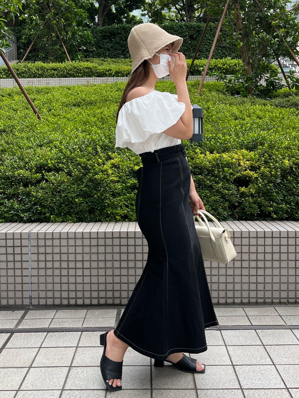 ホワイト系のショルダーバッグ、ホワイト系のシャツ/ブラウス、ブラック系のスカートを着用したレディースの夏コーディネートの2枚目の写真