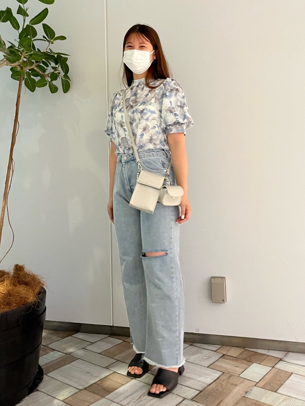 グレー系のシャツ/ブラウス、ブルー系のデニムパンツ、シルバー系のショルダーバッグを着用したレディースの夏コーディネートの3枚目の写真