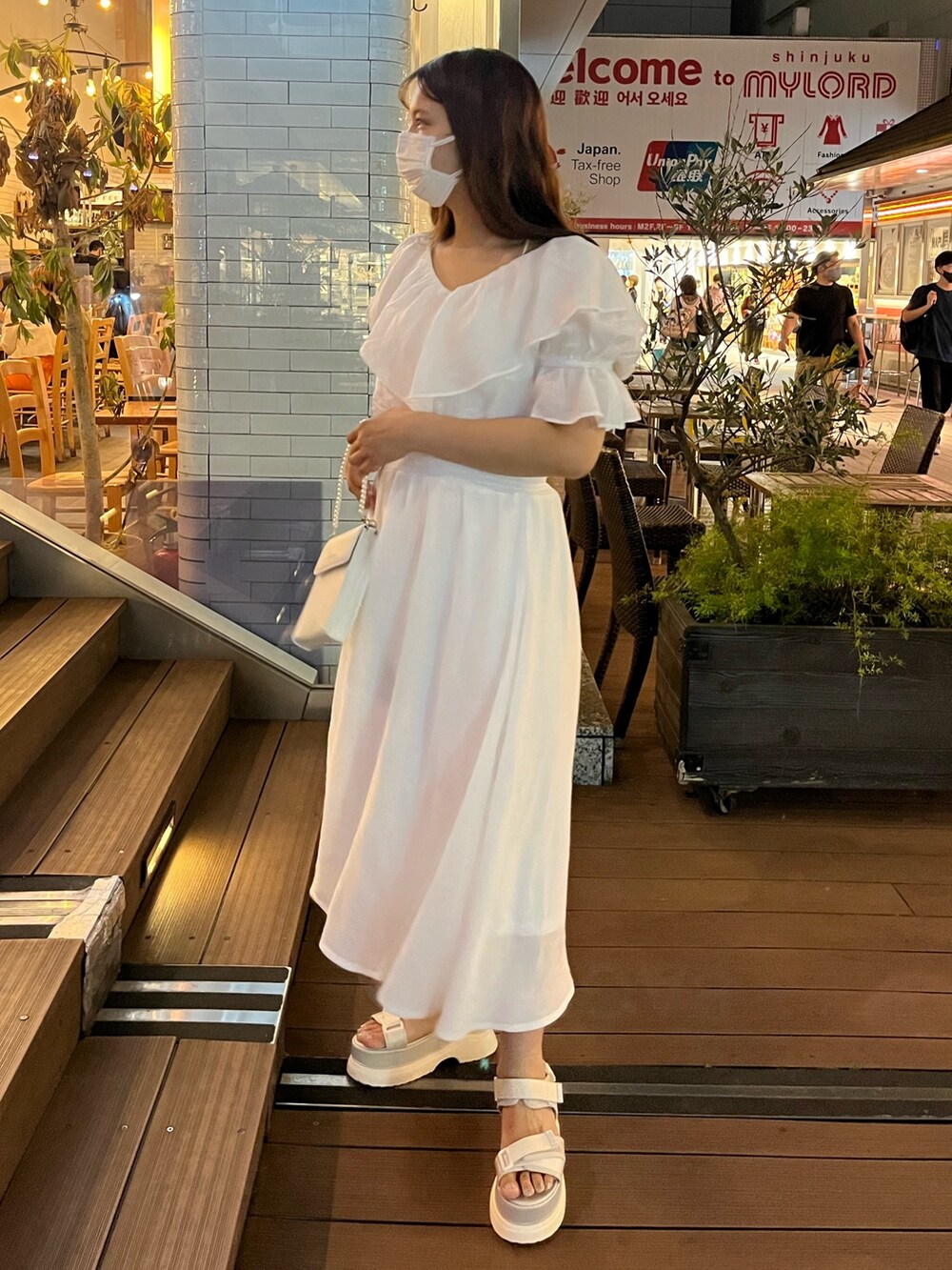 ホワイト系のワンピース、ホワイト系のショルダーバッグ、ホワイト系のサンダルを着用したレディースの夏コーディネートの3枚目の写真