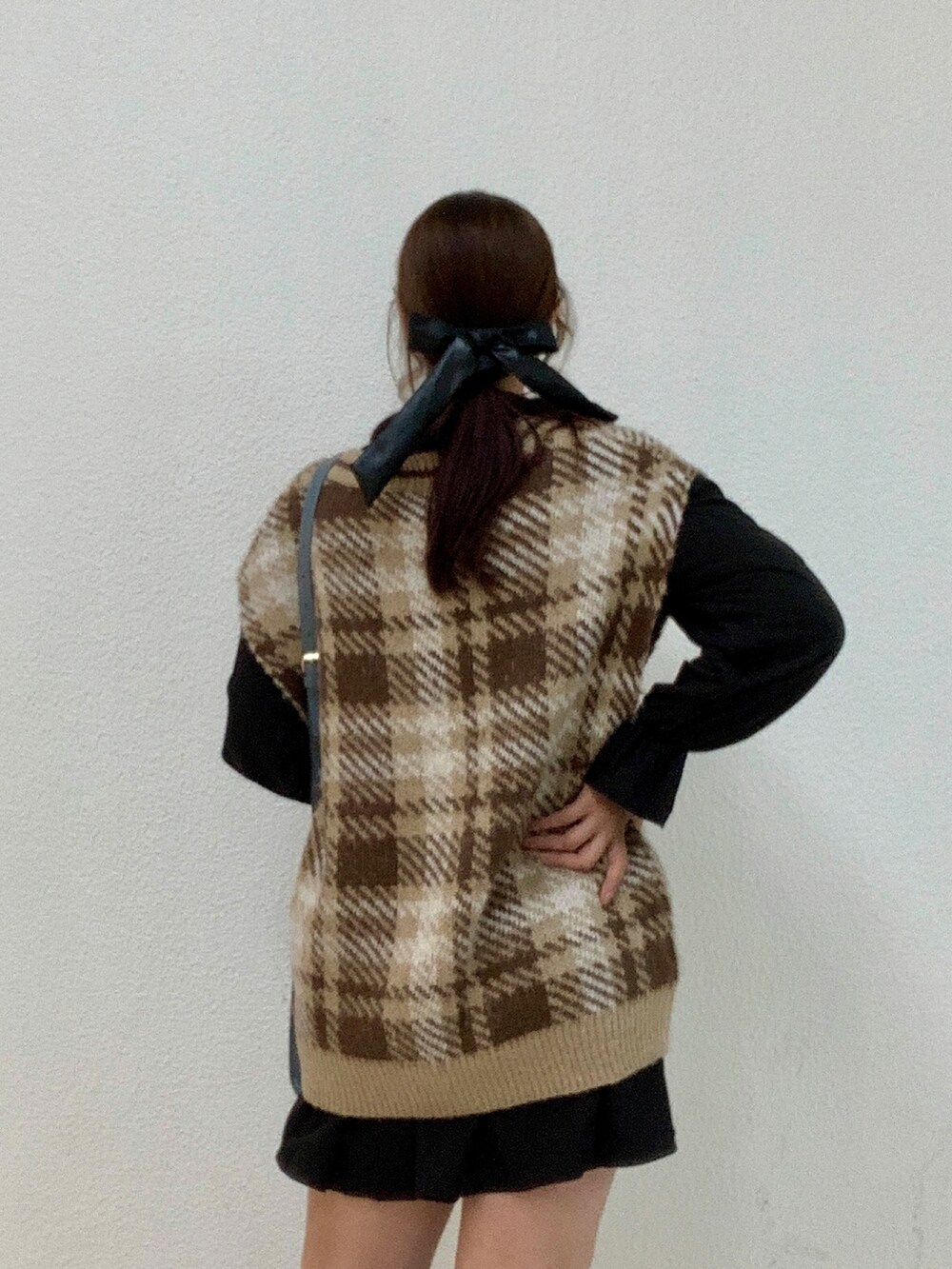 ブラック系のワンピース、ブラウン系のベスト、ブルー系のショルダーバッグを着用したレディースの秋コーディネートの2枚目の写真