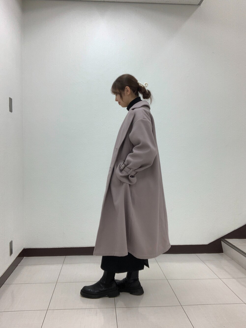 ホワイト系のカーディガン/ボレロ、ブラック系のスカート、ベージュ系のショルダーバッグを着用したレディースの冬コーディネートの2枚目の写真