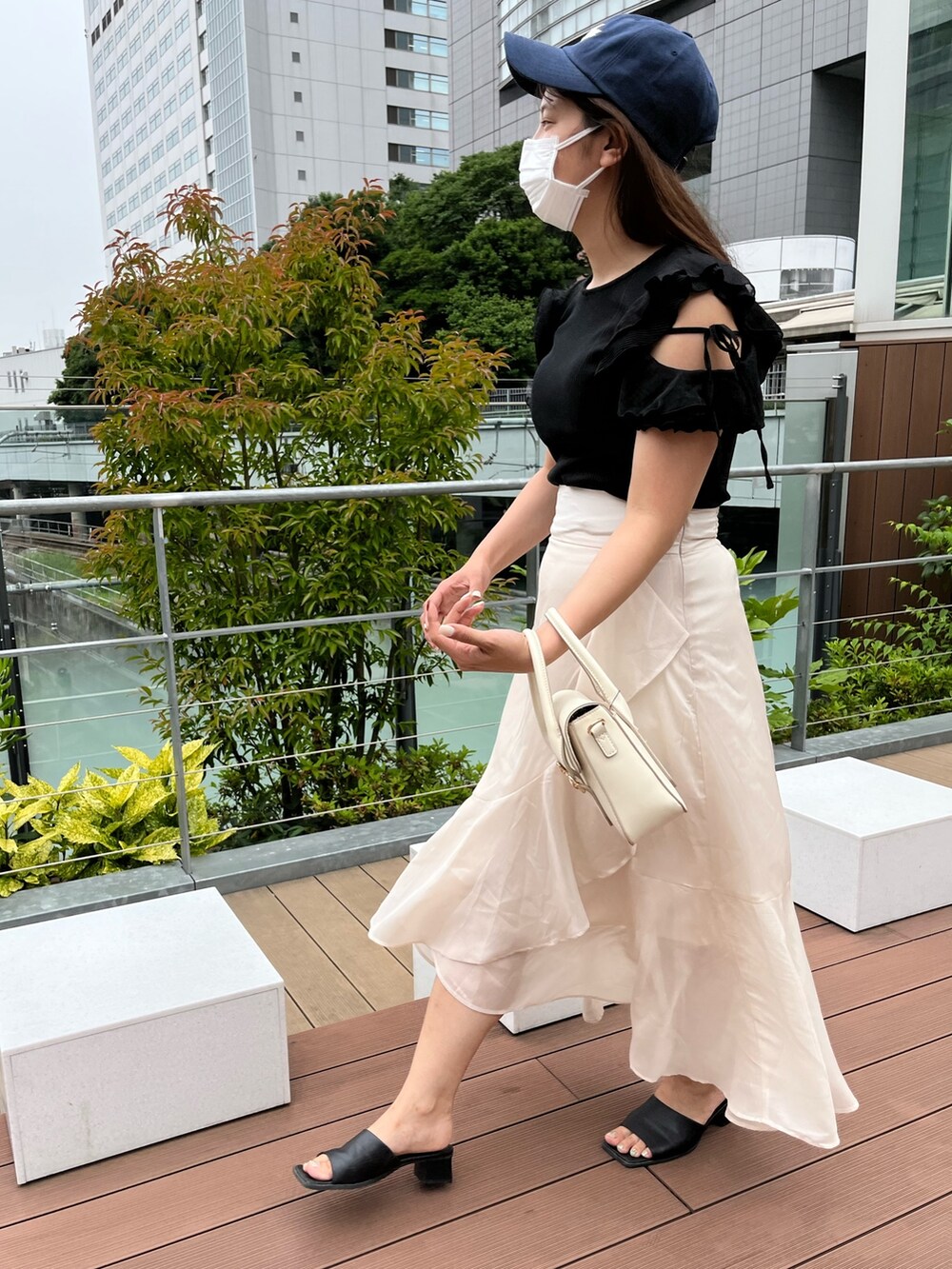 ブラック系のTシャツ/カットソー、ホワイト系のショルダーバッグ、ベージュ系のスカートを着用したレディースの夏コーディネートの5枚目の写真