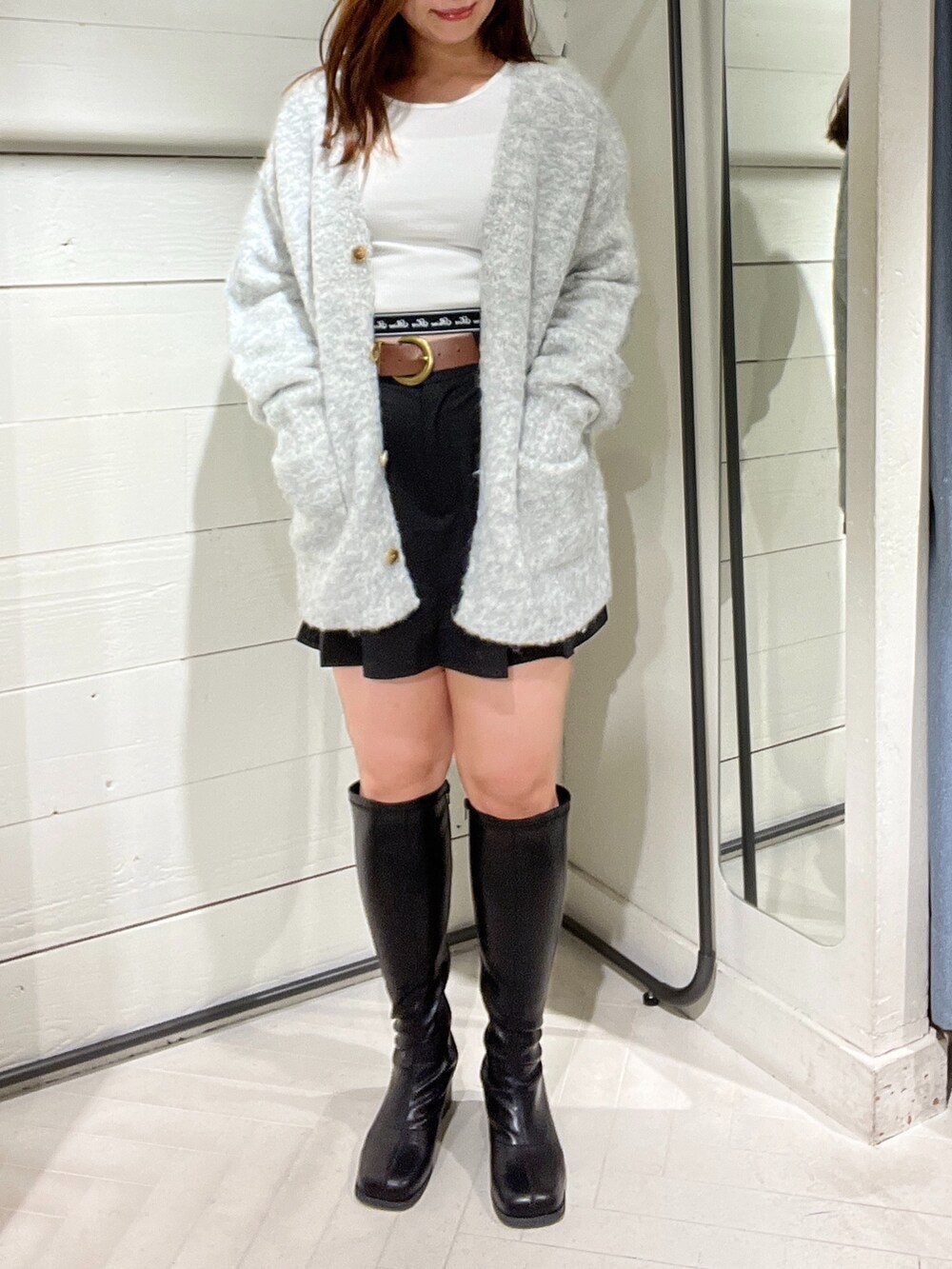 ブラック系のスカート、グレー系のカーディガン/ボレロ、ホワイト系のTシャツ/カットソーを着用したレディースの秋コーディネートの3枚目の写真