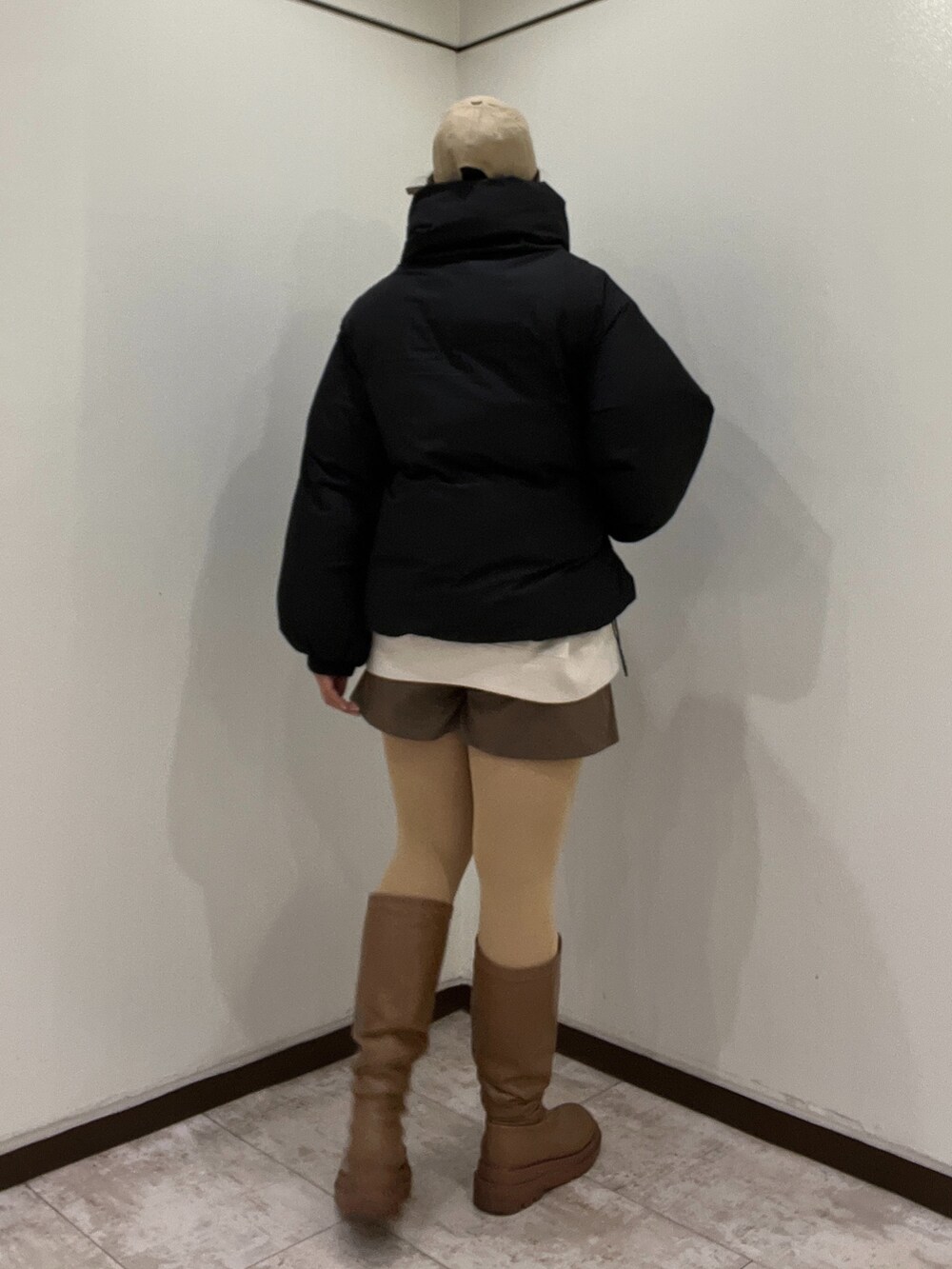 ブラック系のダウンジャケット/コート、ブラウン系のその他パンツ、ホワイト系のスウェットを着用したレディースの冬コーディネートの2枚目の写真