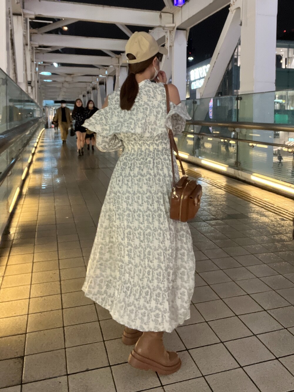 イエロー系のショルダーバッグ、ホワイト系のワンピース、イエロー系のブーツを着用したレディースの秋コーディネートの2枚目の写真