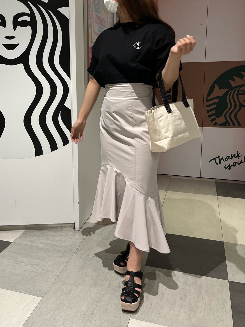 ブラック系のTシャツ/カットソー、ホワイト系のトートバッグ、ホワイト系のスカートを着用したレディースの春コーディネートの3枚目の写真