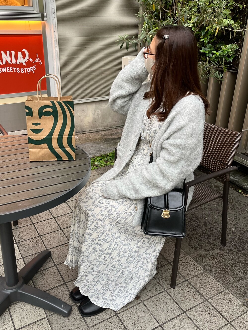 ホワイト系のワンピース、グレー系のカーディガン/ボレロ、ブラック系のショルダーバッグを着用したレディースの秋コーディネートの4枚目の写真