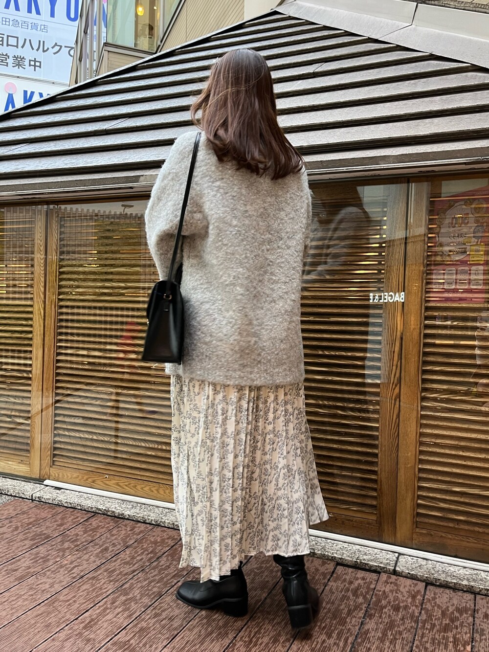 ホワイト系のワンピース、グレー系のカーディガン/ボレロ、ブラック系のショルダーバッグを着用したレディースの秋コーディネートの3枚目の写真