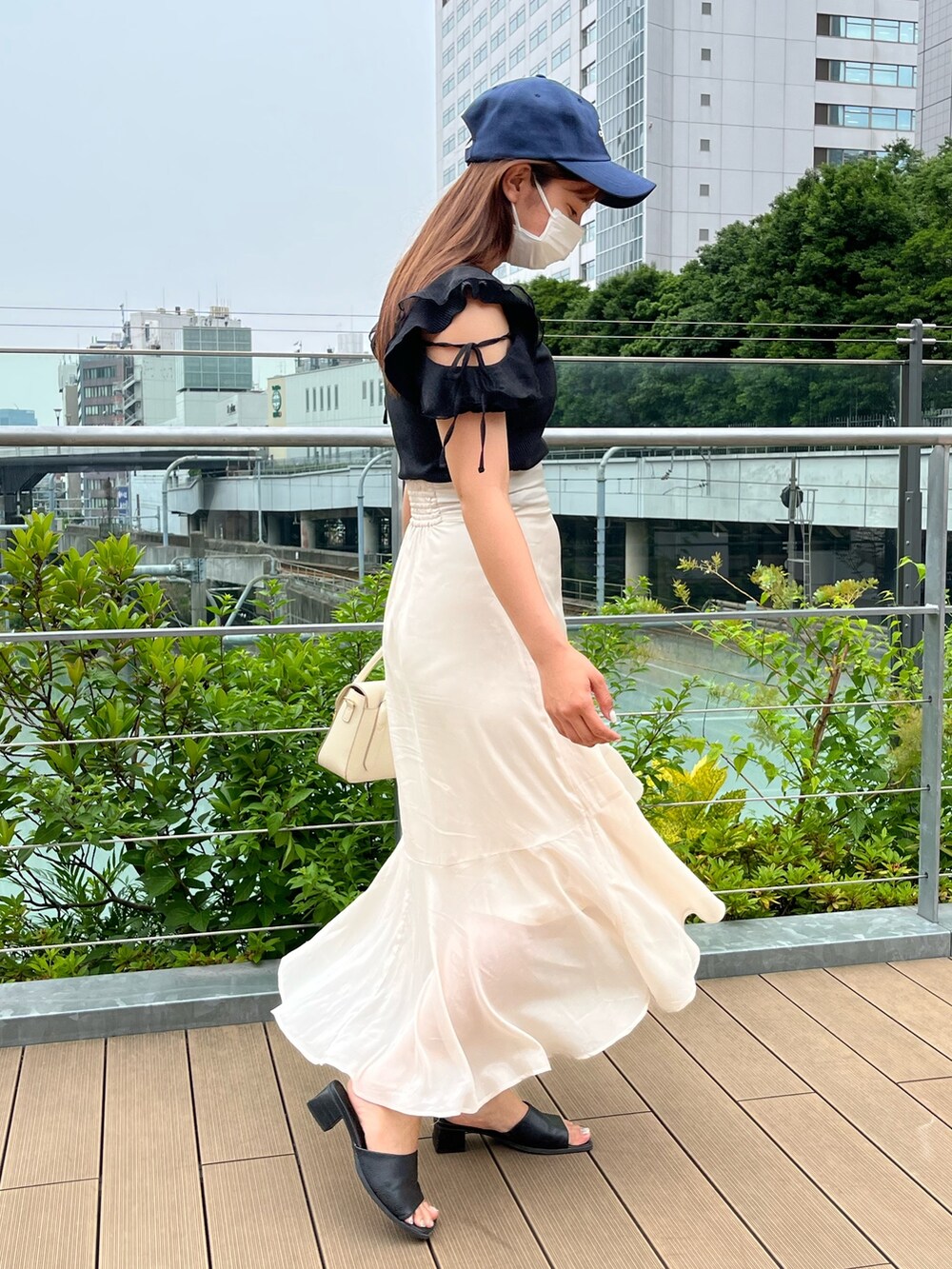 ブラック系のTシャツ/カットソー、ホワイト系のショルダーバッグ、ベージュ系のスカートを着用したレディースの夏コーディネートの3枚目の写真