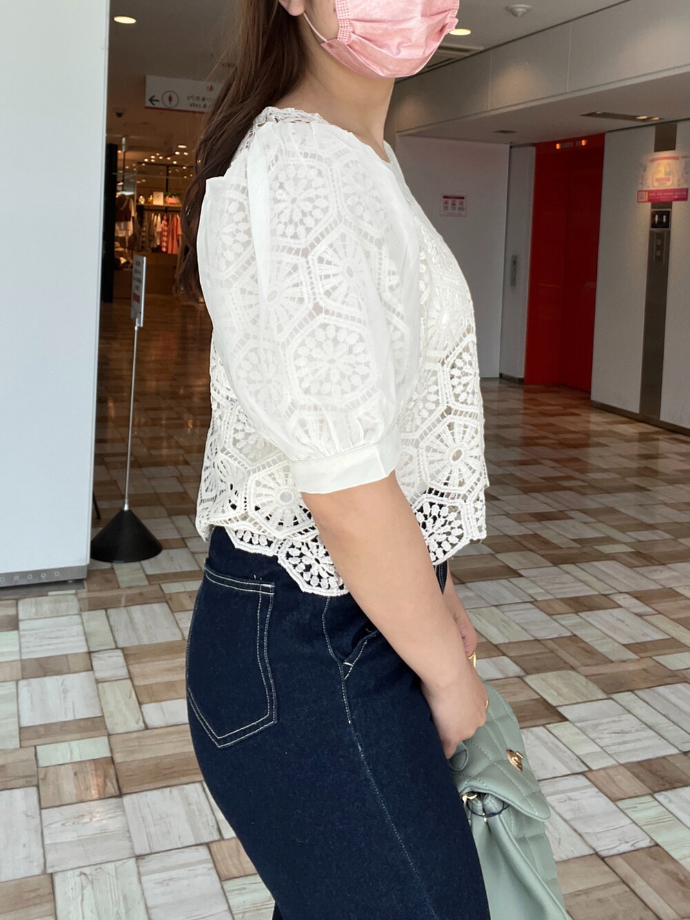 ホワイト系のキャミソール、ホワイト系のシャツ/ブラウス、ブルー系のデニムパンツを着用したレディースの春コーディネートの3枚目の写真