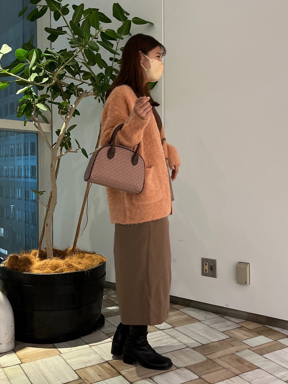 ブラウン系のスカート、ブラック系のその他シューズ、ブラウン系のボストンバッグを着用したレディースの秋コーディネートの2枚目の写真