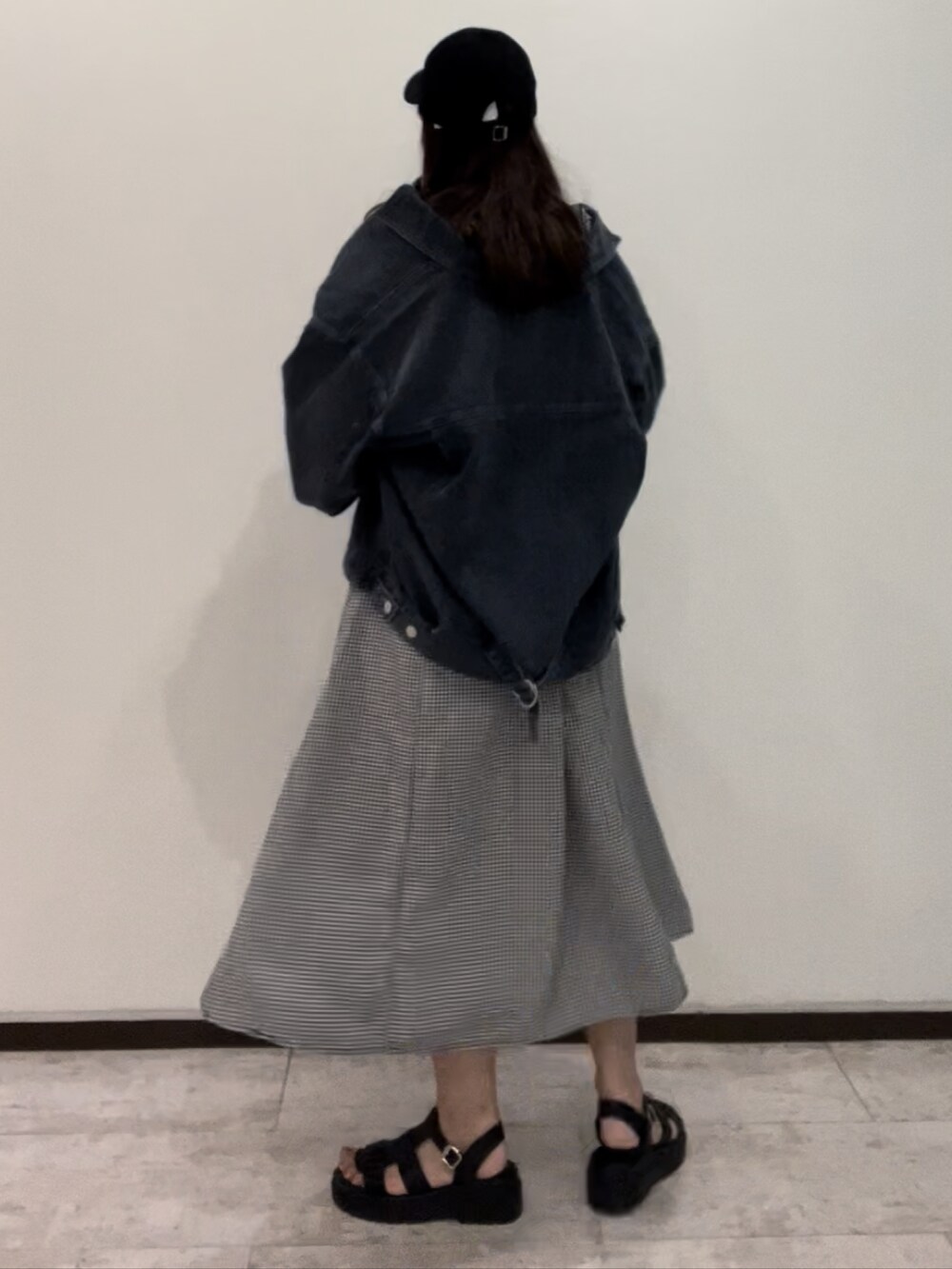 ブルー系のデニムジャケット、ブラック系のワンピース、ブラック系のサンダルを着用したレディースの春コーディネートの3枚目の写真