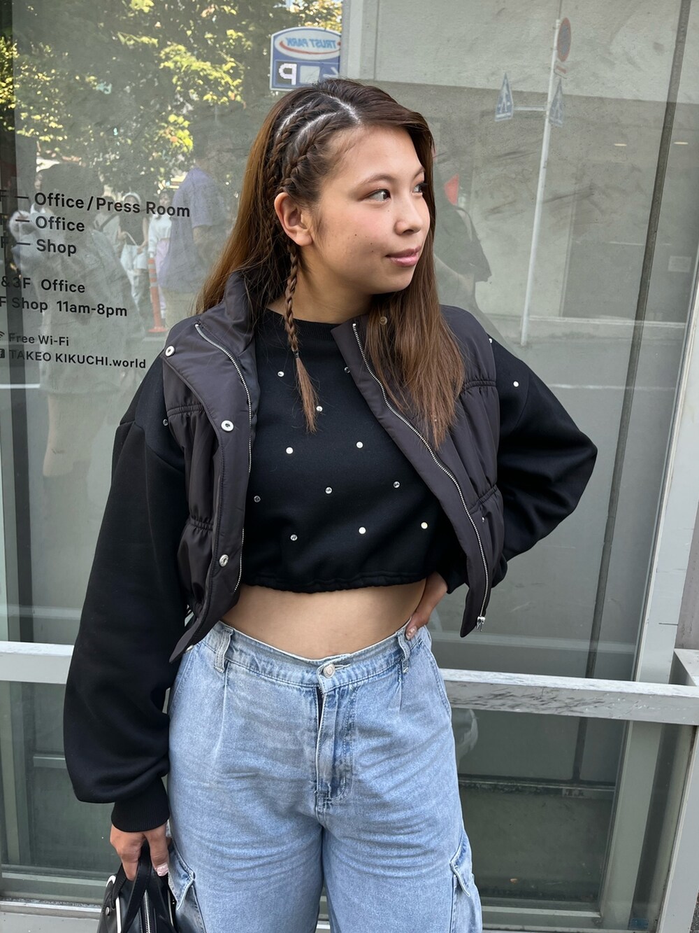 ブラック系のダウンベスト、ブラック系のTシャツ/カットソー、ブルー系のカーゴパンツを着用したレディースの秋コーディネートの2枚目の写真